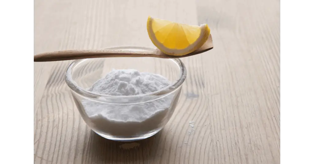 A slice of lemon and a cleaning powder, possibly baking soda