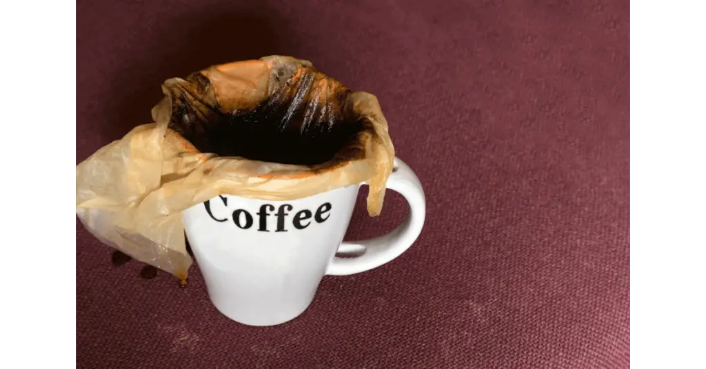 A coffee filter placed in a mug for making coffee on the stove