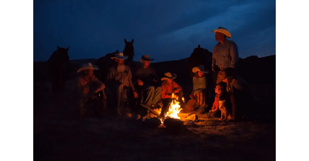 Cowboys sitting around a campire, where cowboy coffee was born