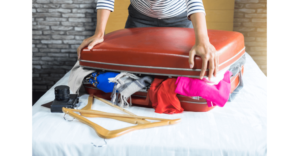 Someone trying to close a full luggage, a case where only the smallest coffee grinder would fit.