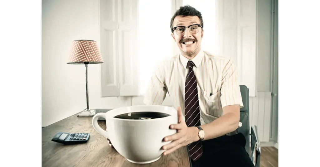 A man with a giant cup of coffee