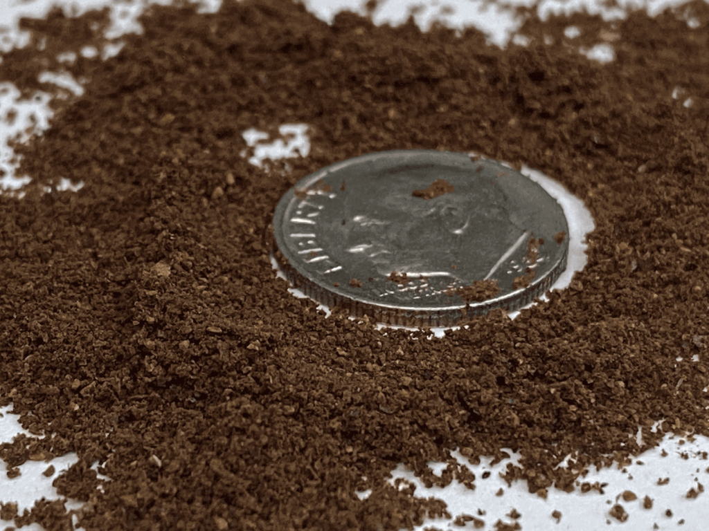 Extra fine grind coffee, with a dime for size comparison