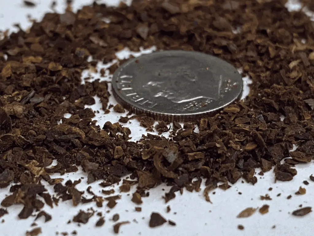 Medium-coarse grind coffee, with a dime for size comparison