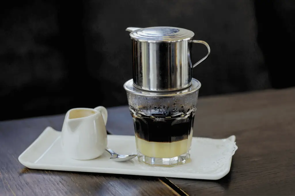 A Vietnamese coffee filter being used to make Vietnamese iced coffee