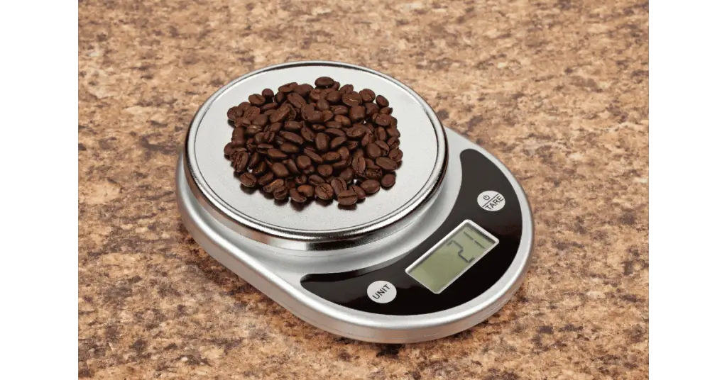Weighing grams of coffee beans on a kitchen scale