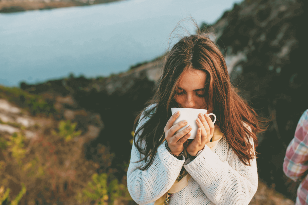 A person enjoying the aroma of coffee, one of the great aspects of premium black coffee