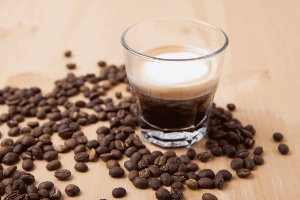 A cafe macchiato in a clear glass to show the coffee-to-milk ratio