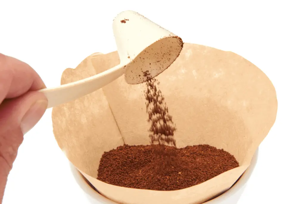 Adding more coffee grounds to a coffee filter