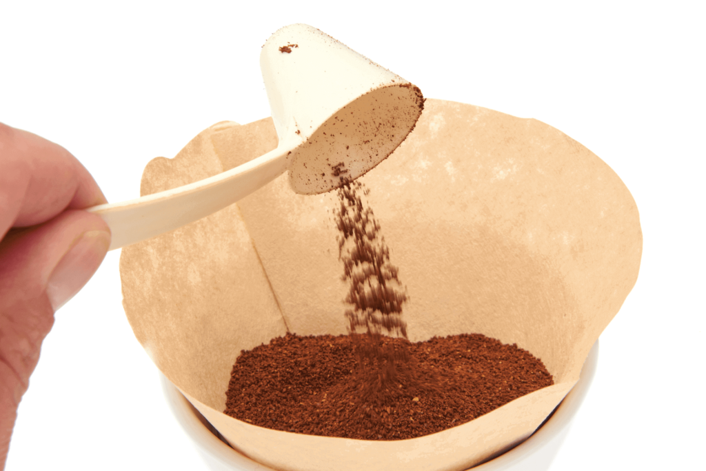 Adding more coffee grounds to a coffee filter