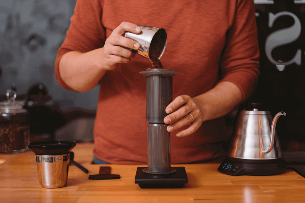 Pouring coffee grounds into an inverted AeroPress coffee maker