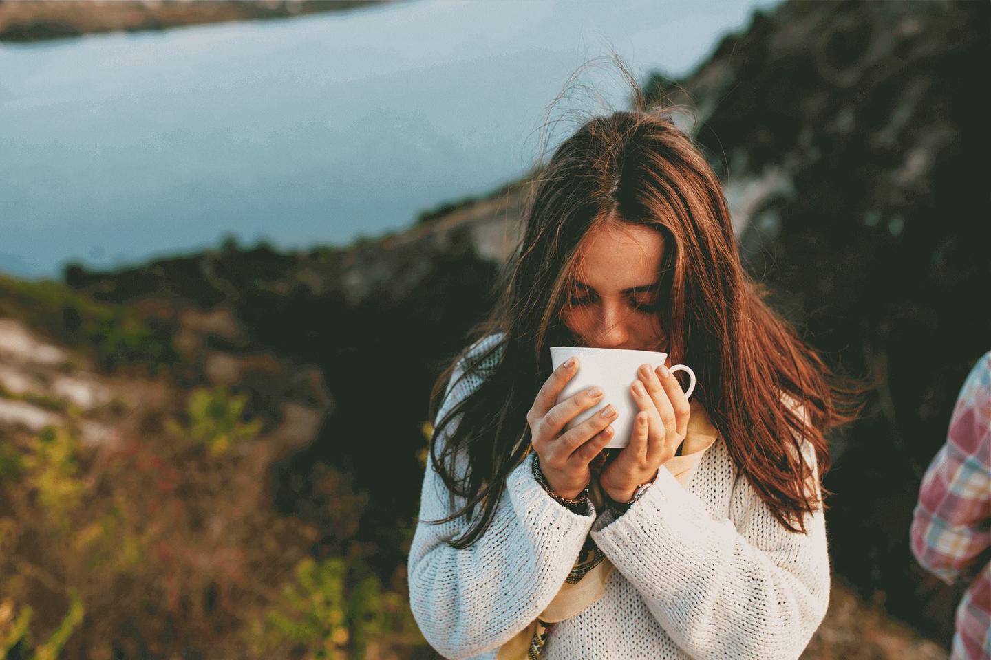 A person enjoying the aroma of coffee, one of the great aspects of premium black coffee