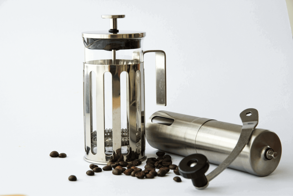 A french press coffee maker and coffee grinder