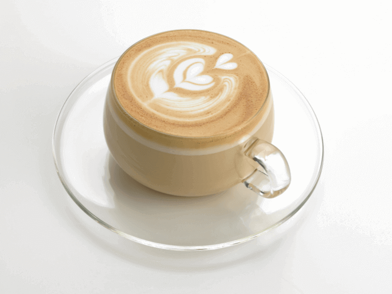 A cafe latte served in a clear mug to show the full espresso drink